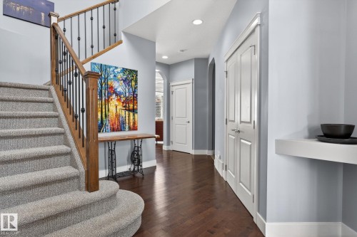 The property features an entryway with hardwood flooring and a carpeted staircase with a wooden banister - 20719 51 Avenue, Edmonton, AB - Indoor Photo Showing Other Room