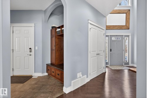 The entryway features a dark hardwood floor, light blue walls, and a white paneled door with a modern lock - 20719 51 Avenue, Edmonton, AB - Indoor Photo Showing Other Room