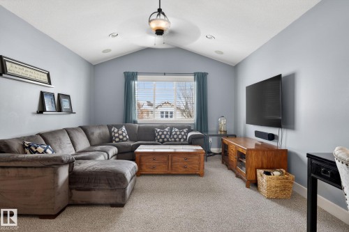 This living area features a vaulted ceiling with a ceiling fan, recessed lighting, and carpeting - 20719 51 Avenue, Edmonton, AB - Indoor Photo Showing Living Room