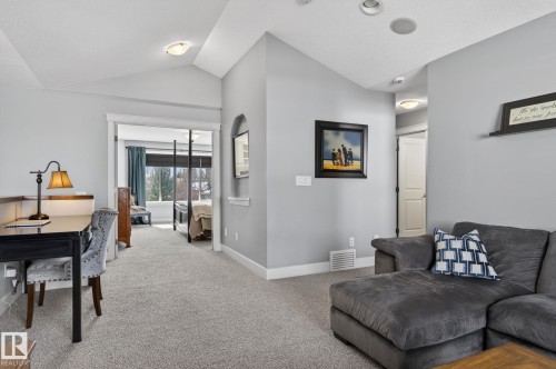 This space features carpeted flooring, light grey walls, and a vaulted ceiling - 20719 51 Avenue, Edmonton, AB - Indoor Photo Showing Living Room