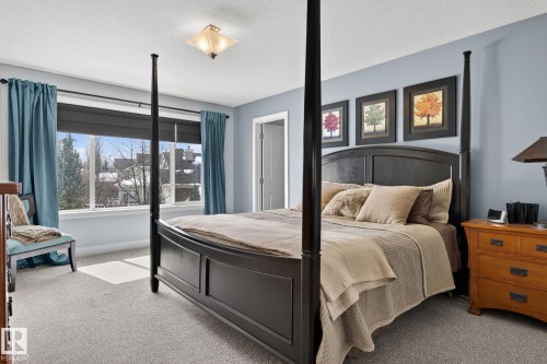 Bedroom featuring light blue walls, a large window with views of trees and rooftops, and a ceiling light fixture - 20719 51 Avenue, Edmonton, AB - Indoor Photo Showing Bedroom