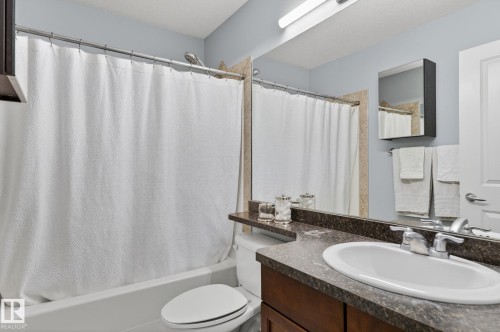 Bathroom featuring a vanity with a countertop, a sink with a faucet, and a large mirror - 20719 51 Avenue, Edmonton, AB - Indoor Photo Showing Bathroom