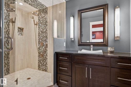 Well-appointed bathroom featuring a spacious shower with dual shower heads and decorative tile accents - 20719 51 Avenue, Edmonton, AB - Indoor Photo Showing Bathroom