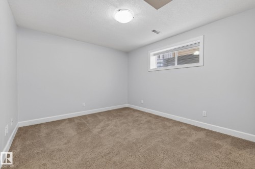 Room featuring light gray walls, brown carpet flooring, and a window providing natural light - 20719 51 Avenue, Edmonton, AB - Indoor Photo Showing Other Room