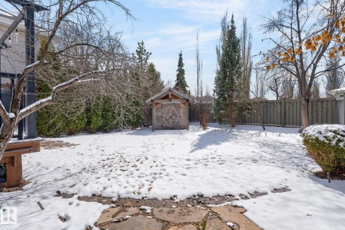 The property features a spacious yard with a wooden shed, mature trees, and a wooden fence - 20719 51 Avenue, Edmonton, AB - Outdoor