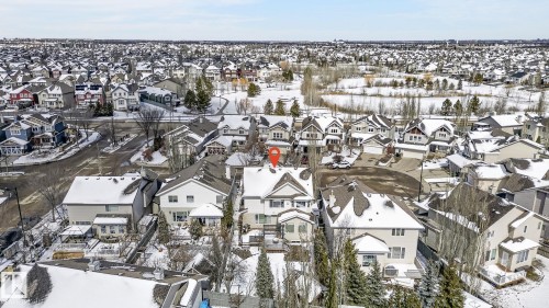 Aerial view showcasing the property situated within a structured residential area, featuring a neighborhood with a pond and extensive tree coverage - 20719 51 Avenue, Edmonton, AB - Outdoor