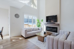 The living area features hardwood floors, a modern fireplace, and large sliding glass doors providing access to the outdoors - 