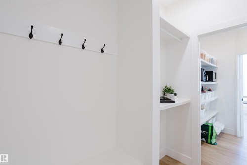The property features a dedicated storage area with a coat rack, shelving, and a pantry with built-in shelving - 79 Silverstone Drive, Stony Plain, AB - Indoor Photo Showing Other Room
