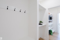 The property features a dedicated storage area with a coat rack, shelving, and a pantry with built-in shelving - 