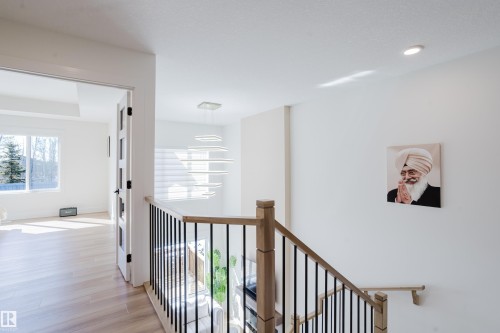 The property features light-toned hardwood flooring, white walls, and a modern light fixture - 79 Silverstone Drive, Stony Plain, AB - Indoor Photo Showing Other Room