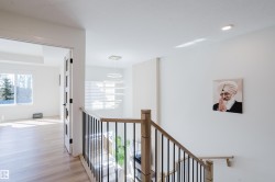 The property features light-toned hardwood flooring, white walls, and a modern light fixture - 