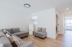 The interior features light wood flooring and white walls throughout - 