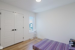 This room features light-colored flooring, a window providing natural light, and a ceiling light fixture - 