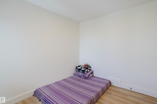 This room features light-colored walls and hardwood-style flooring - 79 Silverstone Drive, Stony Plain, AB - Indoor Photo Showing Bedroom