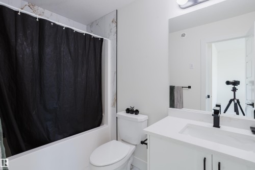 Bathroom featuring a white vanity with a rectangular sink, a black faucet, and a large mirror - 79 Silverstone Drive, Stony Plain, AB - Indoor Photo Showing Bathroom