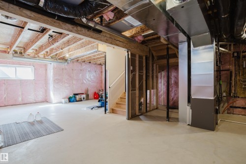The property features an unfinished basement with exposed wooden beams, insulation, and a visible window - 79 Silverstone Drive, Stony Plain, AB - Indoor Photo Showing Basement