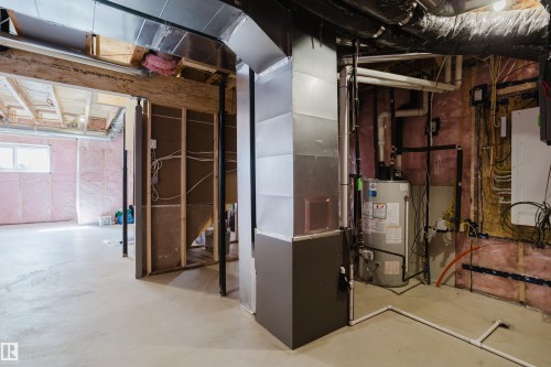 The unfinished basement features a concrete floor, exposed insulation, and a water heater - 79 Silverstone Drive, Stony Plain, AB - Indoor Photo Showing Basement