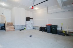 Spacious garage with a concrete floor, overhead lighting, and an overhead garage door opener - 