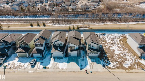 Aerial view of the neighborhood showcasing several properties with dark roofs, attached garages, and a paved street - 79 Silverstone Drive, Stony Plain, AB - Outdoor With View
