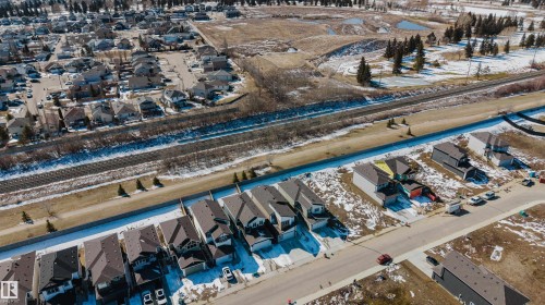 Aerial view showcasing the residential street with a variety of homes, paved roads, and a clear view of the surrounding neighbourhood - 79 Silverstone Drive, Stony Plain, AB - Outdoor With View