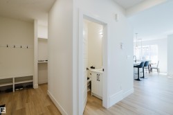 This property features light-colored flooring, white walls, and a built-in bench with storage and coat hooks - 