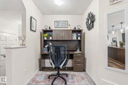 Dedicated workspace featuring a built-in desk with overhead storage and drawers - 