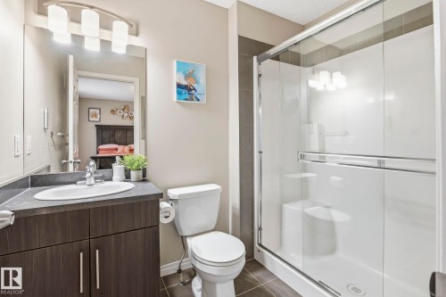 Bathroom featuring a vanity with a sink, a toilet, and a glass-enclosed shower - 4783 Crabapplle Run, Edmonton, AB - Indoor Photo Showing Bathroom