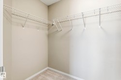 The closet features wire shelving and neutral-toned walls, complemented by a carpeted floor - 