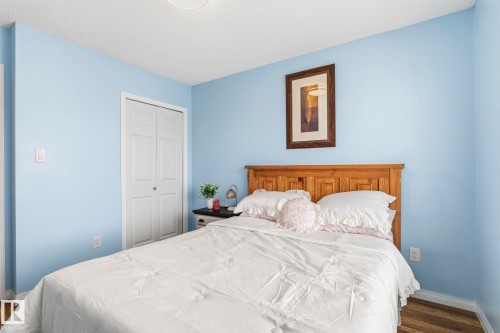 This room features light blue walls, a white ceiling, and hardwood flooring - 4783 Crabapplle Run, Edmonton, AB - Indoor Photo Showing Bedroom
