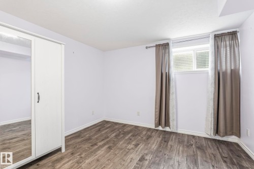 This room features wood-look flooring and a window with blinds - 4783 Crabapplle Run, Edmonton, AB - Indoor Photo Showing Other Room