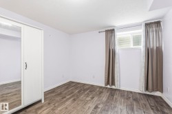This room features wood-look flooring and a window with blinds - 