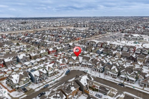 Aerial view of the property and the surrounding neighbourhood, featuring a curved street and residential properties with snow-covered roofs - 4783 Crabapplle Run, Edmonton, AB - Outdoor With View