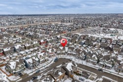 Aerial view of the property and the surrounding neighbourhood, featuring a curved street and residential properties with snow-covered roofs - 