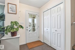 Entryway featuring a white door with a window, dark flooring, and bi-fold doors - 