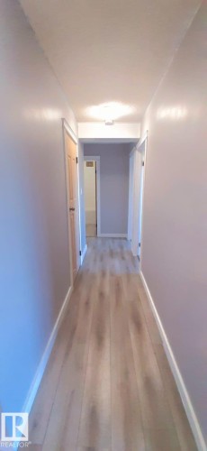 Hallway with light wood-look flooring and light grey walls - 307 6307 118 Ave, Edmonton, AB - Indoor Photo Showing Other Room