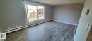 Living area with light grey walls, light-toned wood flooring, and baseboard heating - 307 6307 118 Ave, Edmonton, AB  - Indoor Photo Showing Other Room 