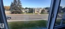The property offers views of mature evergreen trees and a building with an architectural facade - 307 6307 118 Ave, Edmonton, AB  - Outdoor With View 