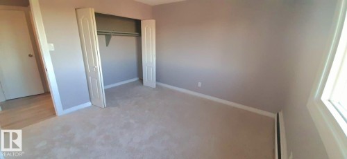 This room features neutral-toned carpet flooring, light-colored walls, and a window providing natural light - 307 6307 118 Ave, Edmonton, AB - Indoor Photo Showing Other Room