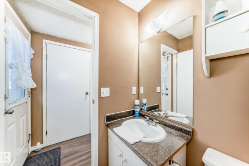 Bathroom vanity with an integrated sink and a large mirror - 6 1580 Millwoods Road E, Edmonton, AB - Indoor Photo Showing Bathroom