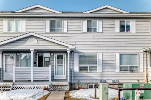 The property features light gray horizontal siding and white window trim - 6 1580 Millwoods Road E, Edmonton, AB - Outdoor With Facade