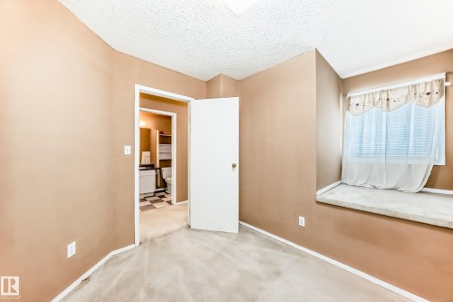 This room features soft-toned walls, a window with blinds and valance, and a carpeted window seat - 6 1580 Millwoods Road E, Edmonton, AB - Indoor Photo Showing Other Room