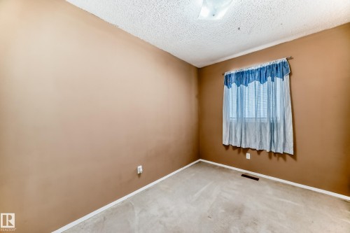 This room features warm-toned walls, a window with blinds, and carpeted flooring - 6 1580 Millwoods Road E, Edmonton, AB - Indoor Photo Showing Other Room