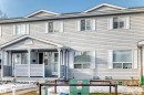 The property features a multi-story exterior with light-colored siding, white window frames, and white shutters - 6 1580 Millwoods Road E, Edmonton, AB  - Outdoor With Facade 