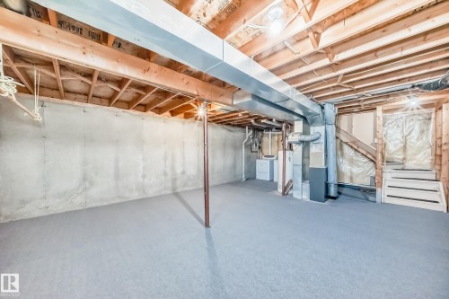 Expansive unfinished basement with exposed wooden ceiling beams and concrete walls - 6 1580 Millwoods Road E, Edmonton, AB - Indoor Photo Showing Basement