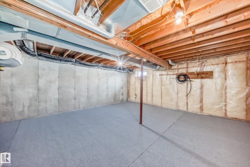 Unfinished basement featuring concrete walls, a support beam, exposed ceiling joists, and a window - 6 1580 Millwoods Road E, Edmonton, AB - Indoor Photo Showing Basement