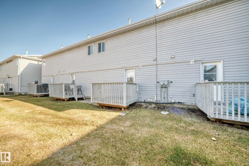 The property features a fenced yard with a lawn and multiple decks - 6 1580 Millwoods Road E, Edmonton, AB - Outdoor With Exterior