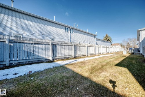 The property features a fenced yard with a grassy area - 6 1580 Millwoods Road E, Edmonton, AB - Outdoor