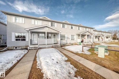 The property features a two-story exterior with light-colored siding, a covered front porch, and white window shutters - 6 1580 Millwoods Road E, Edmonton, AB - Outdoor