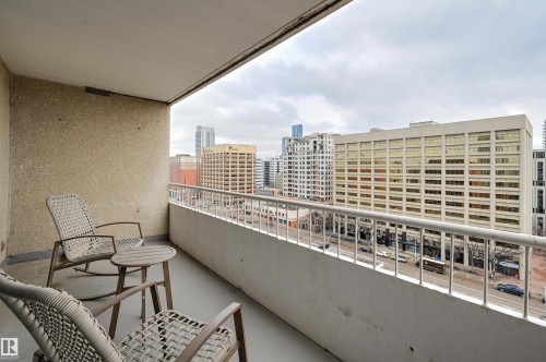 The property offers a balcony with a city view, featuring a white railing and a concrete floor - 1202 9909 110 Street Nw, Edmonton, AB - Outdoor With Balcony With Exterior
