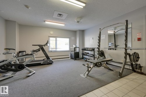 Dedicated fitness area featuring a treadmill, exercise bike, and weight training equipment - 1202 9909 110 Street Nw, Edmonton, AB - Indoor Photo Showing Gym Room